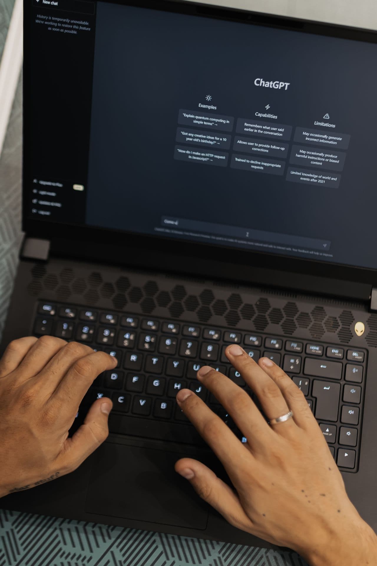 Mężczyzna piszący na laptopie z widocznym interfejsem ChatGPT na ekranie